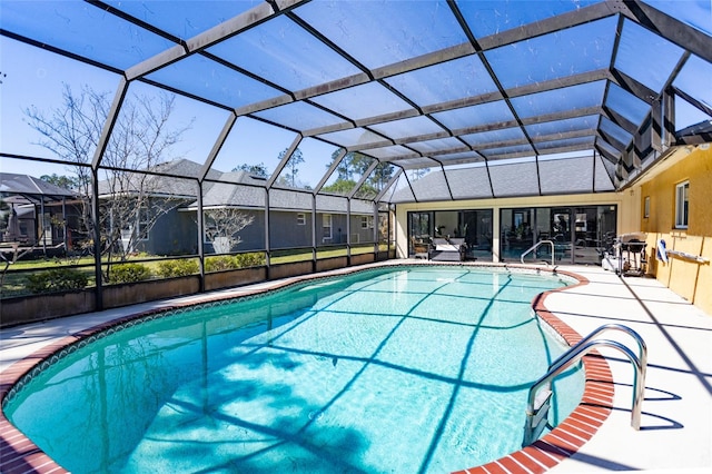 outdoor pool with a residential view, glass enclosure, and a patio