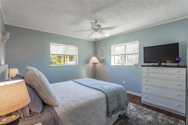 bedroom featuring ceiling fan, dark wood-type flooring, multiple windows, and ornamental molding