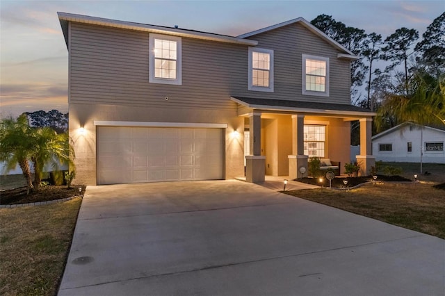 traditional-style home featuring covered porch, stucco siding, concrete driveway, and a garage