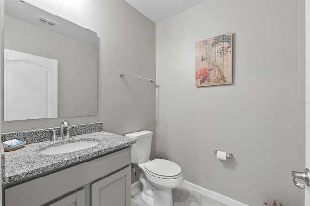 bathroom featuring visible vents, toilet, vanity, and baseboards