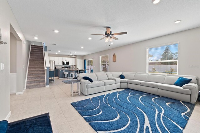 living area featuring stairway, light tile patterned floors, and recessed lighting