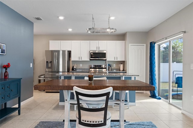 kitchen with white cabinetry, a kitchen island with sink, visible vents, and appliances with stainless steel finishes