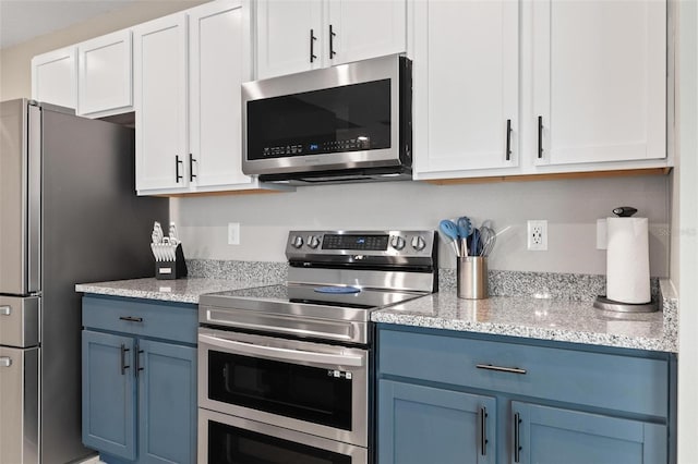 kitchen featuring light stone counters, white cabinets, stainless steel appliances, and blue cabinets