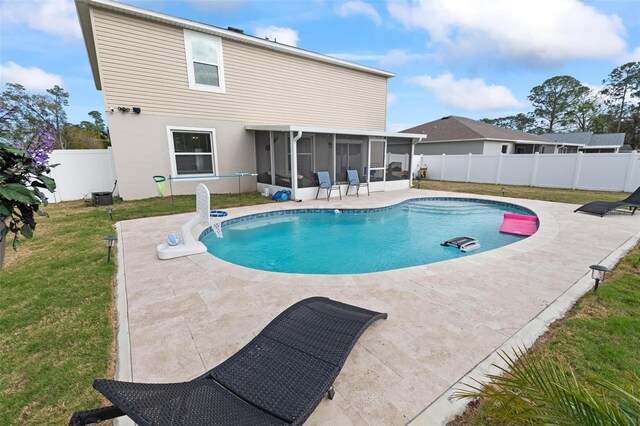 view of swimming pool with a fenced in pool, a lawn, a fenced backyard, a sunroom, and a patio