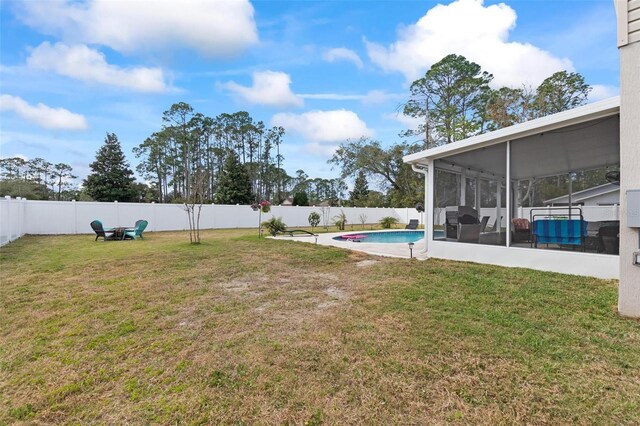 view of yard with a fenced backyard and a sunroom