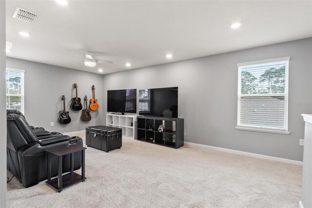 living room with a wealth of natural light, visible vents, baseboards, and carpet