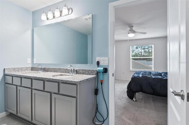 full bath with ceiling fan, baseboards, and a sink