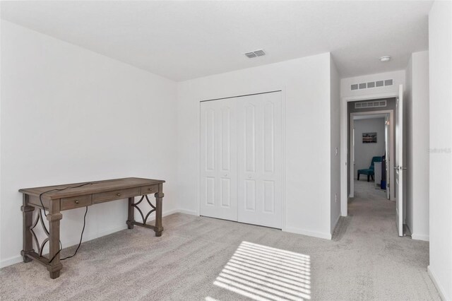 carpeted office with baseboards and visible vents