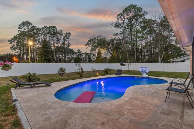 view of swimming pool featuring a patio area, a lawn, and a fenced backyard