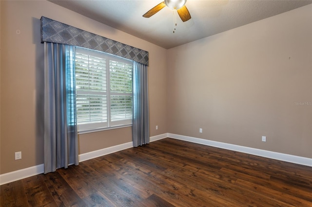 unfurnished room featuring baseboards, a ceiling fan, and dark wood-style flooring