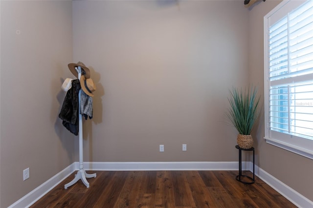 spare room featuring dark wood-style floors and baseboards