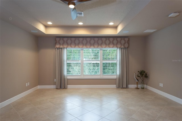 unfurnished room featuring recessed lighting, a raised ceiling, visible vents, and baseboards