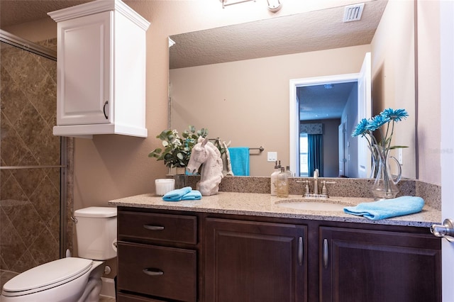 bathroom featuring toilet, visible vents, a textured ceiling, and vanity