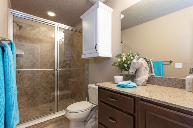 bathroom with toilet, a shower stall, and a textured ceiling