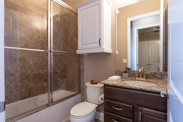 bathroom with toilet, shower / bath combination with glass door, and vanity