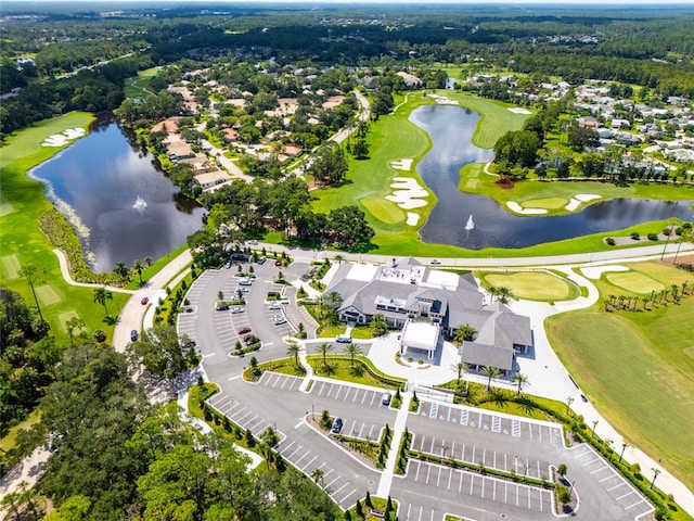 drone / aerial view featuring a water view, view of golf course, and a residential view