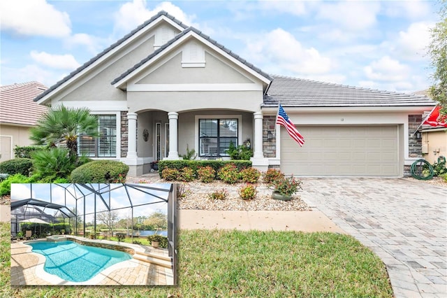 view of front of property featuring a tile roof, decorative driveway, a garage, stone siding, and an outdoor pool