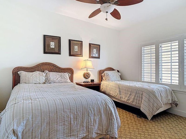 carpeted bedroom with baseboards and ceiling fan