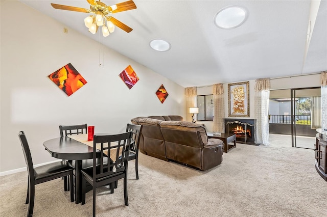 interior space with ceiling fan, baseboards, and a lit fireplace