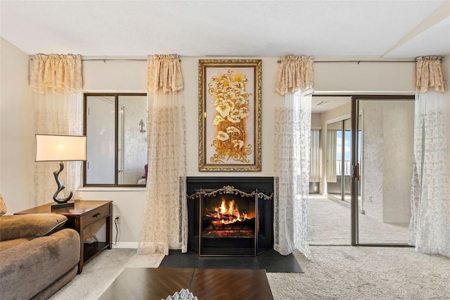 living room with a fireplace with flush hearth, baseboards, and carpet