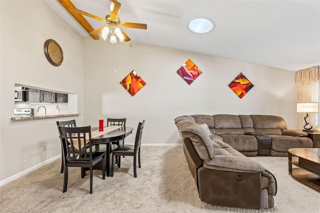 dining area with lofted ceiling, a ceiling fan, baseboards, and light carpet