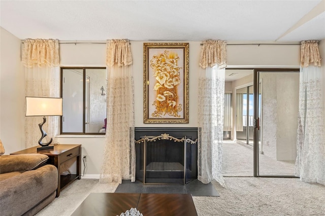 living room featuring carpet flooring, baseboards, and a fireplace with flush hearth