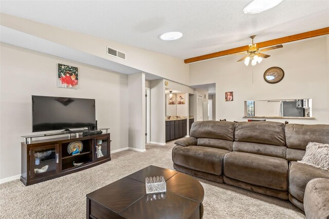 carpeted living room with visible vents, baseboards, a ceiling fan, and vaulted ceiling