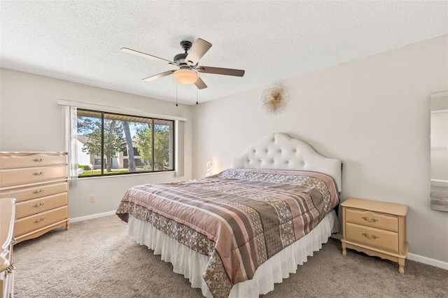 bedroom featuring light colored carpet, a textured ceiling, baseboards, and ceiling fan