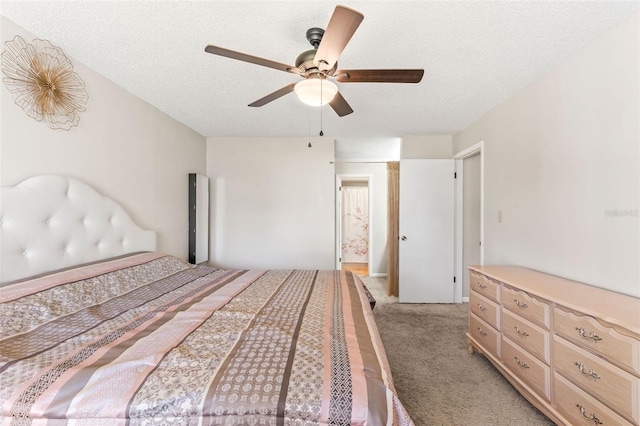 unfurnished bedroom featuring light colored carpet, ceiling fan, and a textured ceiling