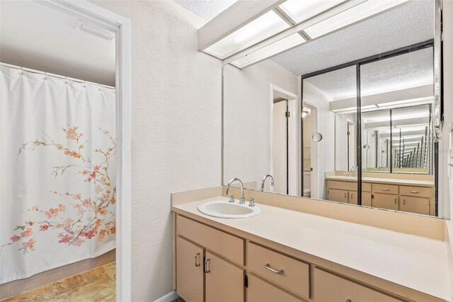 bathroom featuring vanity, curtained shower, toilet, and a textured ceiling