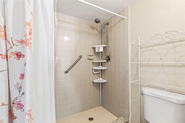 full bathroom with tiled shower and toilet