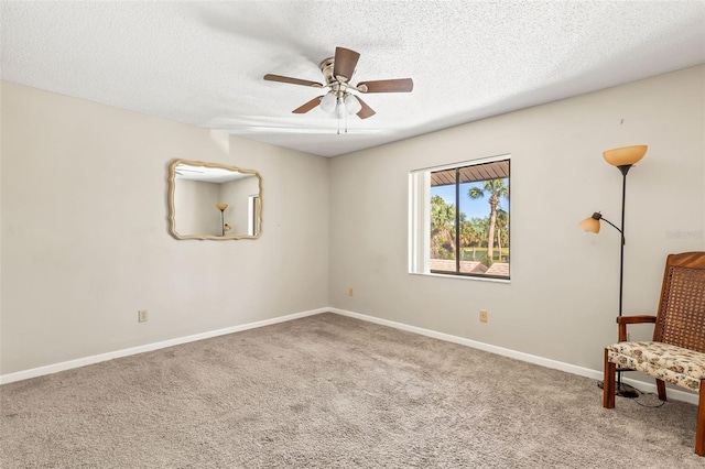 unfurnished room featuring a ceiling fan, baseboards, carpet floors, and a textured ceiling