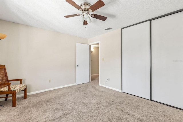 unfurnished bedroom with baseboards, visible vents, a closet, a textured ceiling, and carpet flooring