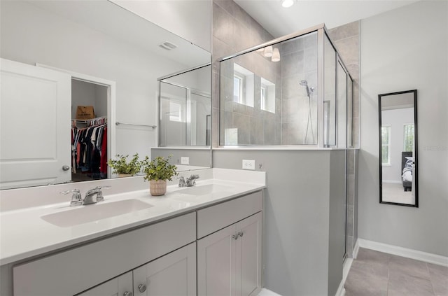 full bath with a shower stall, a spacious closet, double vanity, and a sink