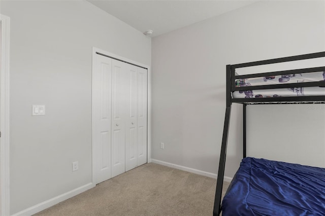 unfurnished bedroom featuring a closet, baseboards, and carpet flooring