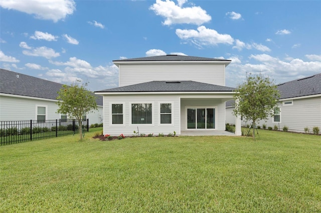 rear view of property with a yard, a shingled roof, a patio, and fence