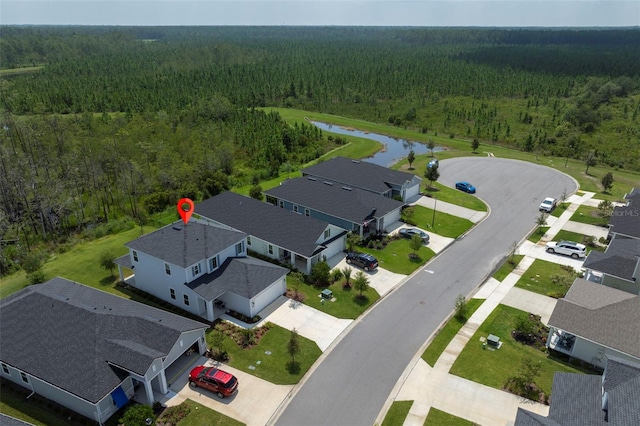 aerial view featuring a forest view and a water view