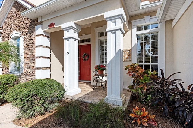 view of exterior entry featuring stucco siding and a porch