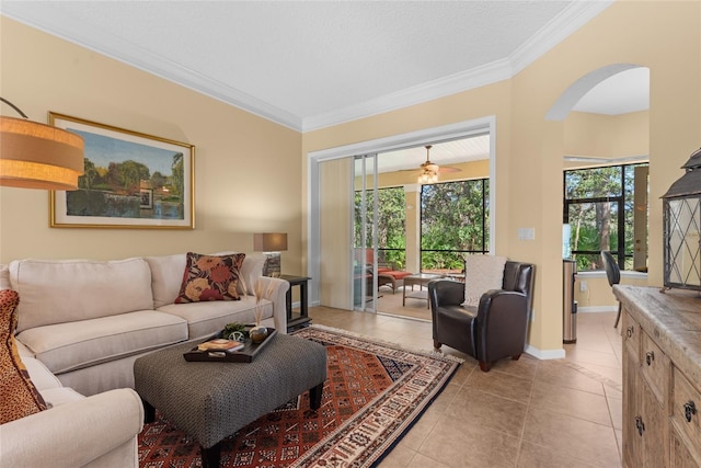 living room featuring light tile patterned floors, baseboards, arched walkways, and crown molding