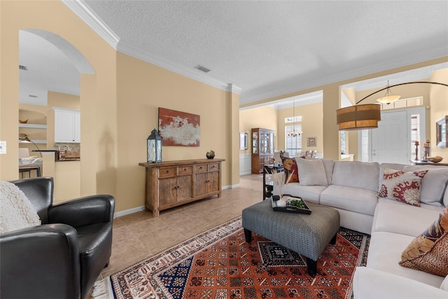 living room featuring visible vents, crown molding, light tile patterned floors, arched walkways, and a textured ceiling