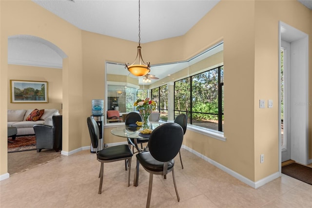 dining space featuring baseboards and arched walkways