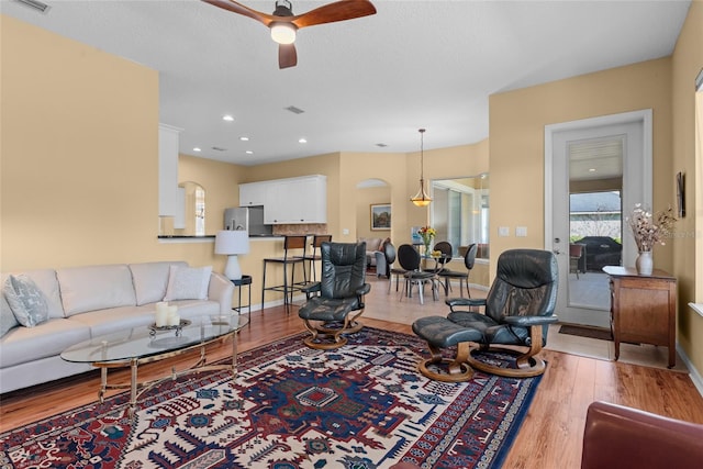 living area featuring wood finished floors, visible vents, baseboards, recessed lighting, and ceiling fan