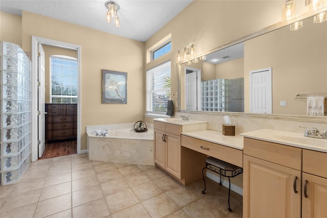 bathroom featuring double vanity, a bath, tile patterned floors, and a sink