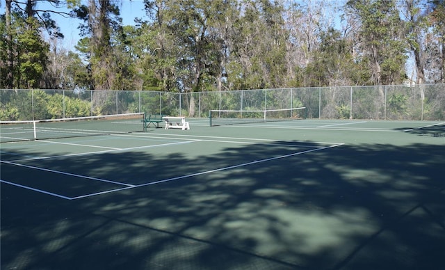 view of tennis court featuring fence