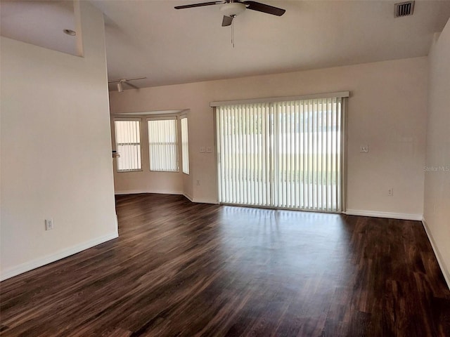 spare room featuring baseboards, visible vents, dark wood-style flooring, and ceiling fan