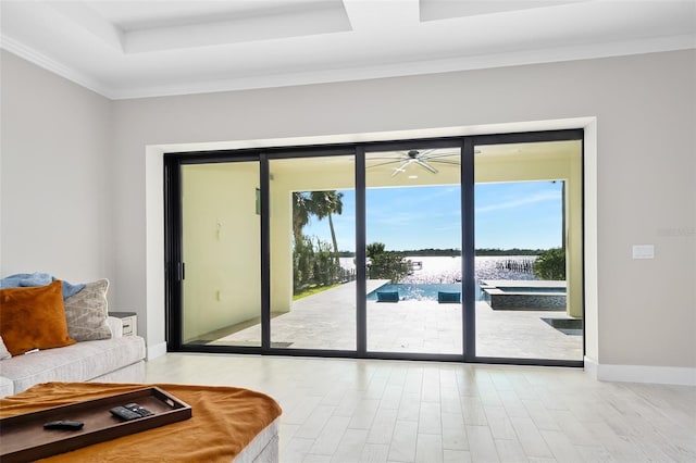 doorway to outside with baseboards, a tray ceiling, and wood finished floors