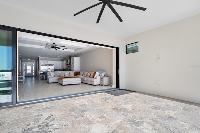 unfurnished living room with stone finish floor and a ceiling fan