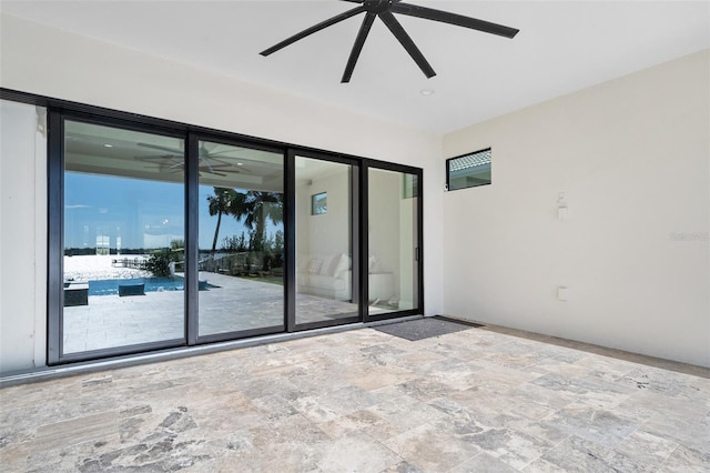 spare room with stone finish floor and ceiling fan