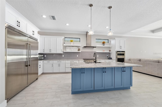 kitchen with visible vents, open shelves, a sink, appliances with stainless steel finishes, and wall chimney range hood