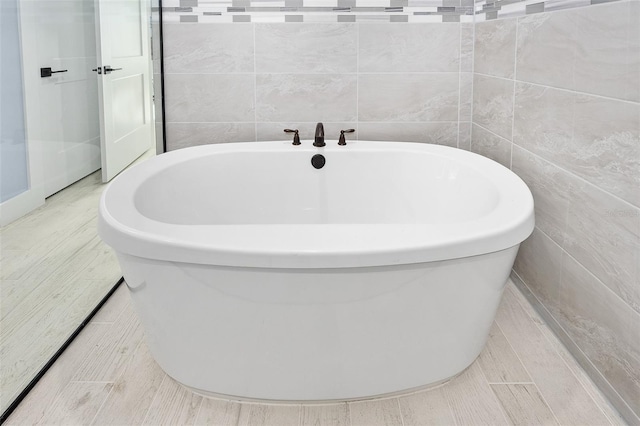 full bath featuring a freestanding bath and tile walls